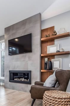 a living room with a couch, chair and television mounted on the wall above it