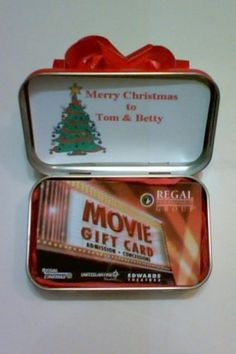 an open tin with a christmas tree and movie gift card in the top right side