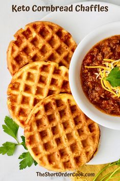 three waffles on a white plate with chili and cheese in the middle next to them