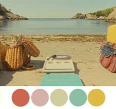 there is a picnic on the beach with two bags and a cooler next to it