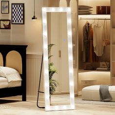 a large mirror with lights on it in a room next to a bed and dresser