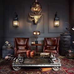 a living room with two chairs and a coffee table in front of an animal head mounted on the wall