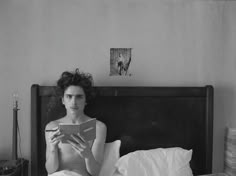 a woman sitting in bed reading a book