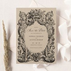 an elegant wedding save the date card on top of a piece of paper with a dried plant