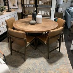 a wooden table with chairs around it in a room filled with furniture and decor items