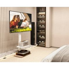 a flat screen tv mounted to the side of a wall next to a night stand