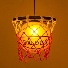 a basketball net hanging from the ceiling with an orange light in it's center