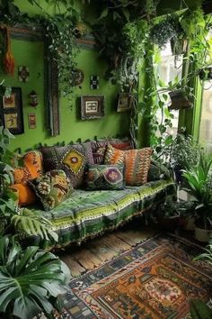 a living room filled with lots of green plants and pillows on top of a couch