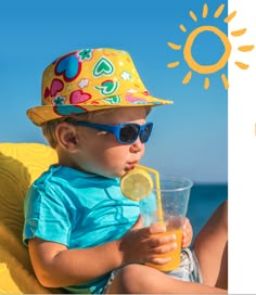 a little boy sitting on a beach chair holding a drink and wearing a sun hat