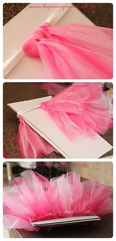 pink tulle skirt sitting on top of a piece of paper next to a laptop