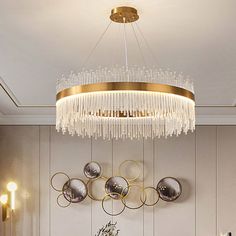 a chandelier hanging from the ceiling in a room with white walls and gold accents