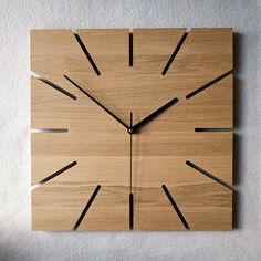 a square wooden clock with black hands on a white wall in an apartment or office