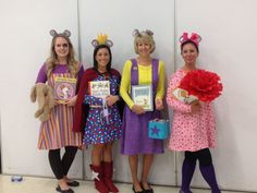 four women dressed in costumes standing next to each other