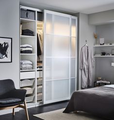 a bedroom with a bed, chair and closets in it's center area