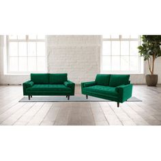 two green couches sitting next to each other in front of a white brick wall