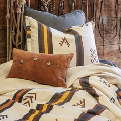 a bed topped with lots of pillows next to a wooden headboard covered in rope