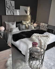 a bedroom with white and black decor on the walls, flooring and bedding