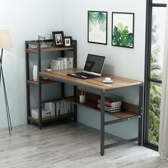 a laptop computer sitting on top of a wooden desk next to a book case and lamp