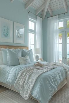 a bedroom with blue walls and white bedding in the center, along with pictures on the wall