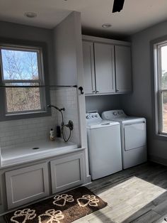 a washer and dryer sitting in a room next to a window with no curtains