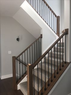 an empty staircase in a house with white walls and wood handrails that lead up to the second floor