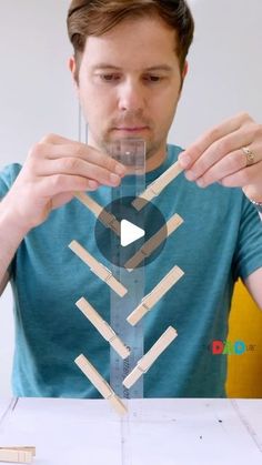 a young man is making something out of popsicle sticks and glues with his hands