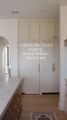 an image of a kitchen with white cabinets and natural linens on the countertops