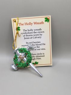 an ornament with a holly wreath and two bells hanging from it's side