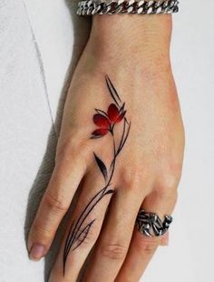 a woman's hand with a flower tattoo on it