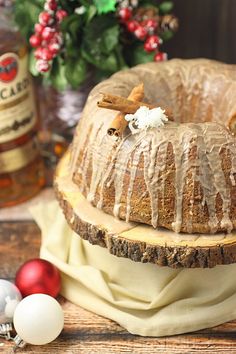 a cake sitting on top of a wooden table next to christmas decorations and baubles