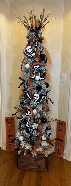 a decorated christmas tree in the corner of a room with orange and black decorations on it