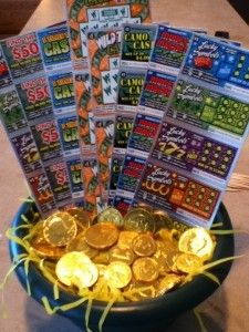 a bowl filled with lots of gold coins on top of a table next to stacks of cards