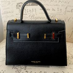 Teddy Blake New York Ava Bag Black Pebbled Leather Top Handle Satchel, Black Top Handle Satchel With Logo, Teddy Blake Handbags, High-end Black Top Handle Box Bag, On-the-go Black Top Handle Briefcase, Teddy Blake, Top Handle, Black Gray, Leather Bag