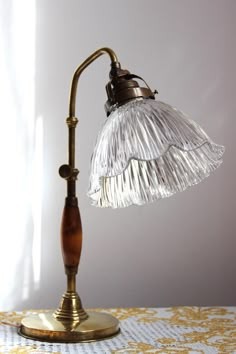 an old fashioned desk lamp on a table