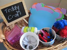 a basket filled with lots of crafting supplies next to a chalkboard and sign