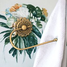 an antique brass towel ring with a sunflower on it