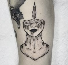 a black and white photo of a candle tattoo