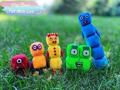 four colorful stuffed animals sitting in the grass with an easy store title overlay that reads, felt monster love