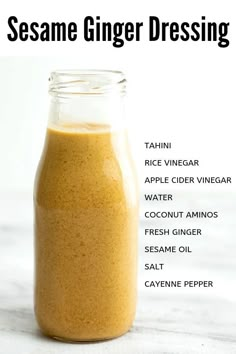 the ingredients for sesame ginger dressing in a glass bottle on a white surface with text overlay