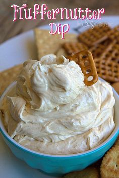 a blue bowl filled with whipped cream surrounded by crackers