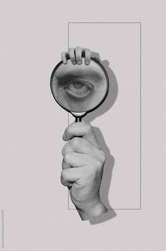 a hand holding a magnifying glass over a white square with the image of an eye in it