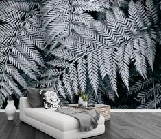 a living room filled with furniture and a wall covered in black and white foliages