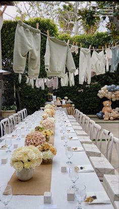 a long table is set with white linens and flowers