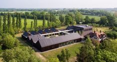 an aerial view of a house in the middle of trees and grass with lots of windows