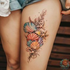 a woman's thigh with seashells and starfish tattoo on her thighs