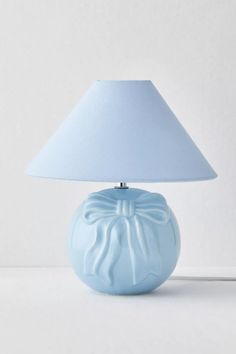 a blue table lamp with a white shade on the bottom and a light blue base