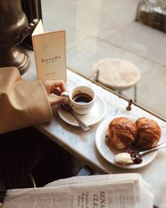 a person sitting at a table with coffee and pastries