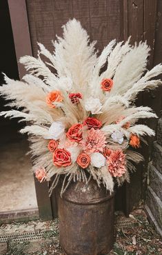 an old bucket with flowers and feathers in it