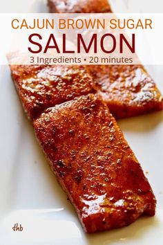 two pieces of salmon on a white plate with the title cajun brown sugar salmon