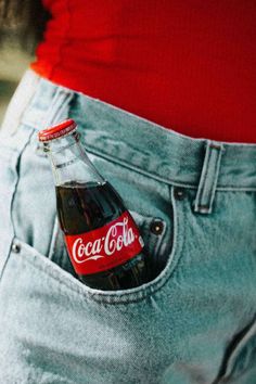 a coca cola bottle in the back pocket of someone's jeans